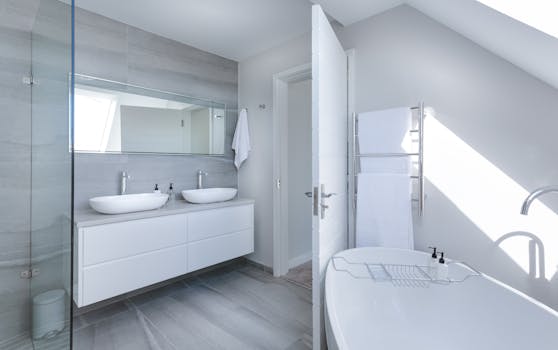 About Us Sleek contemporary bathroom with bathtub and twin sinks, showcasing minimalist design and luxury.